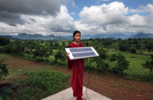 Woman from a rural part of India holds a solar panel.