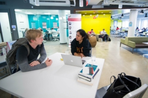 Two student meet at a table.