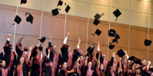 Graduates toss their caps in the air.