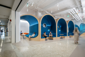 Realistic photo illustration of four large architectural vaults with seats and tables underneath where students are sitting