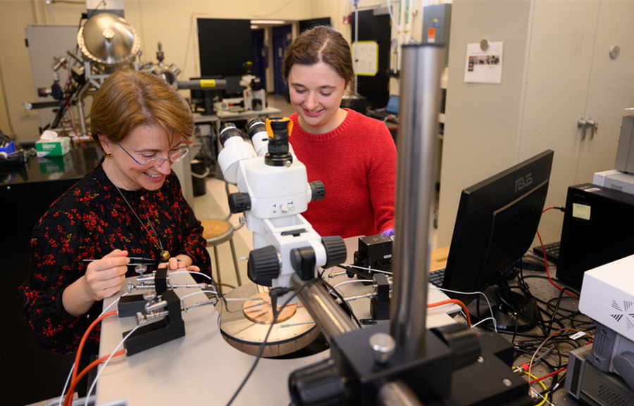 An MIT graduate student and her advisor work at a probe station, measuring the electrical resistance of a tungsten oxide film.