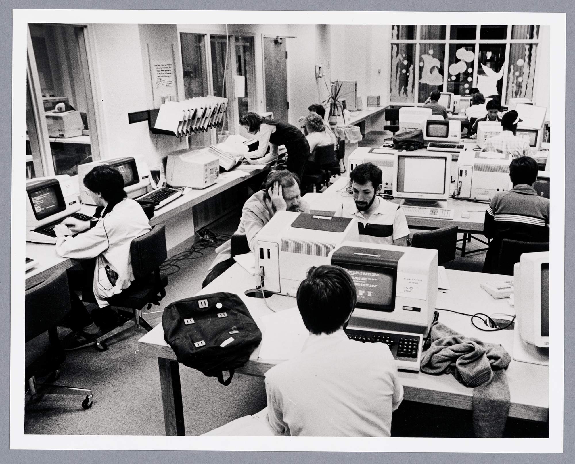 Black and white photo of Project Athena space, where people work at computer terminals.